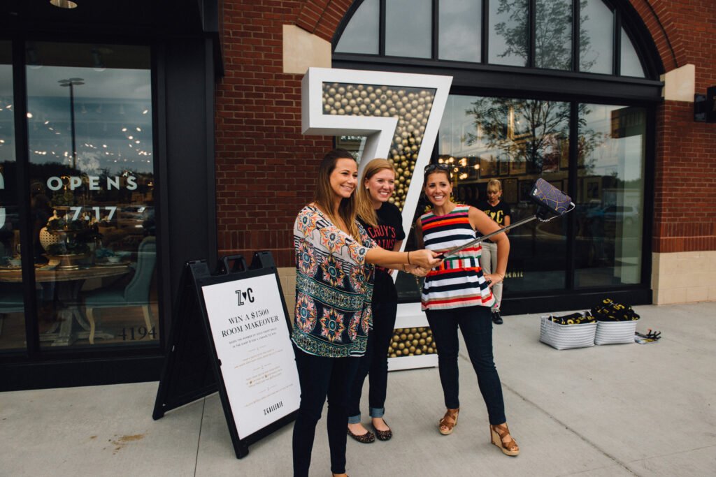 3 women pose for a selfie with a big Z filled with gold balls
